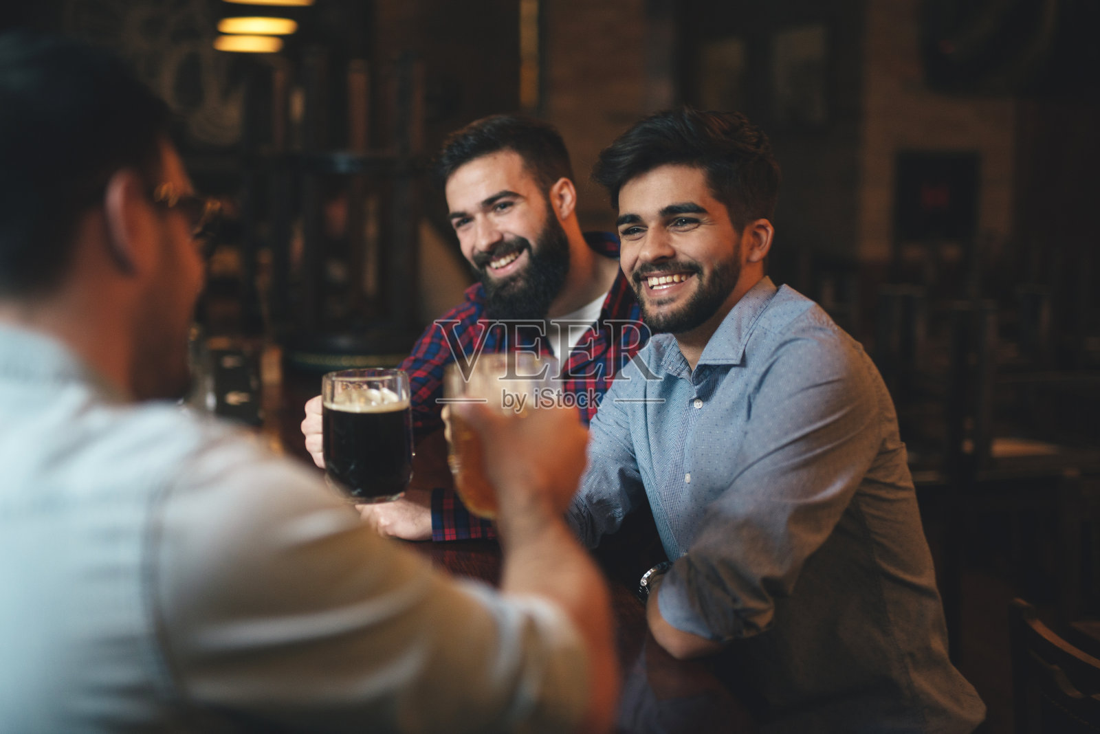 男人们在酒吧看足球,喝啤酒照片摄影图片