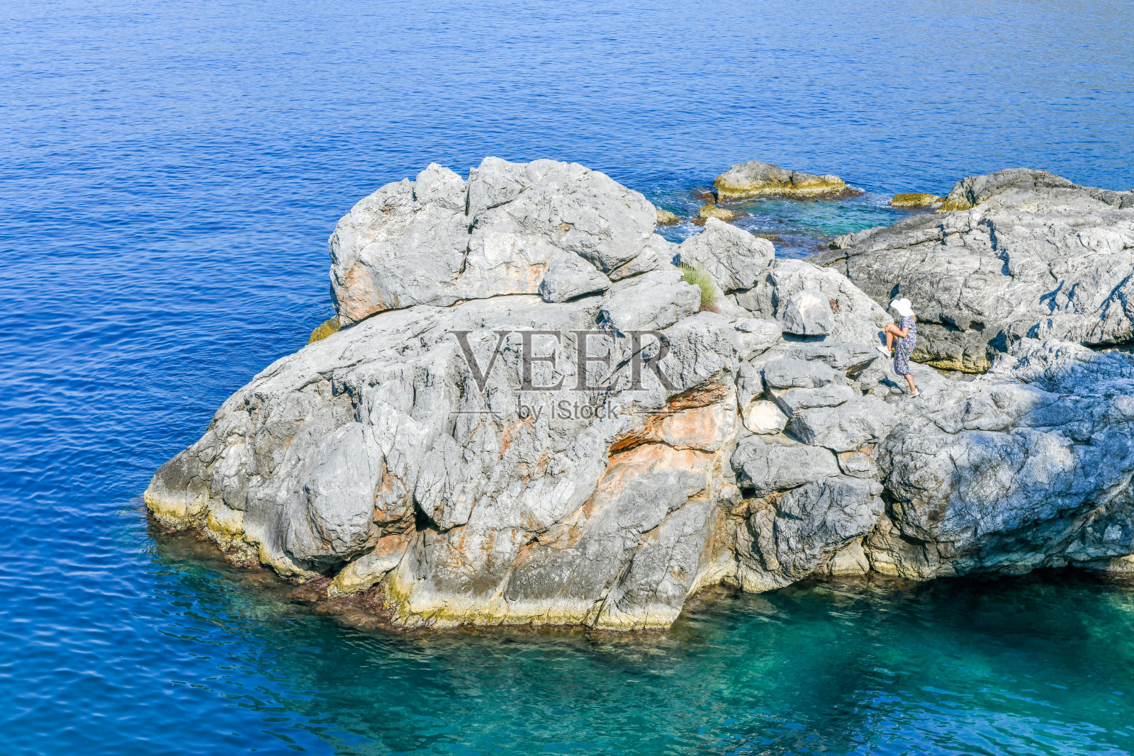 岩石海滩上的女人。照片摄影图片