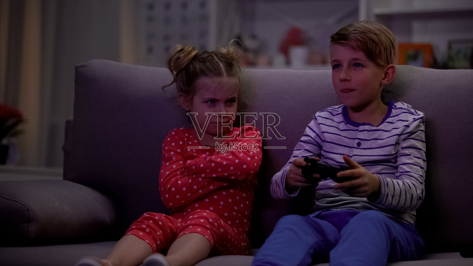 弟弟用操纵杆玩电子游戏,妹妹因为输了而生气照片摄影图片