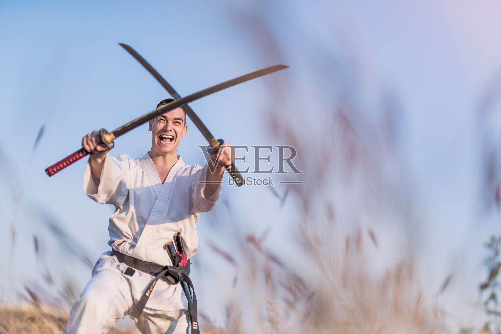 狂暴的武术家练习技巧与两个武士刀。照片摄影图片