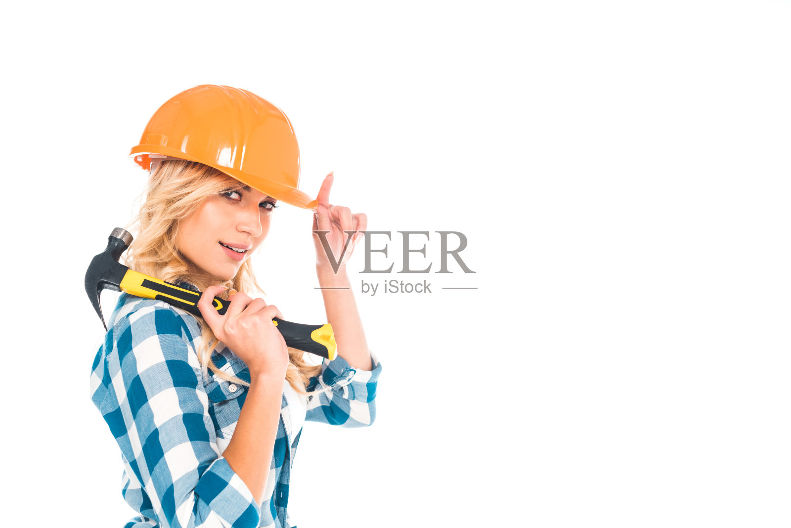 金发便利的女人在蓝色衬衫和橙色安全帽与锤子孤立在白色照片摄影图片