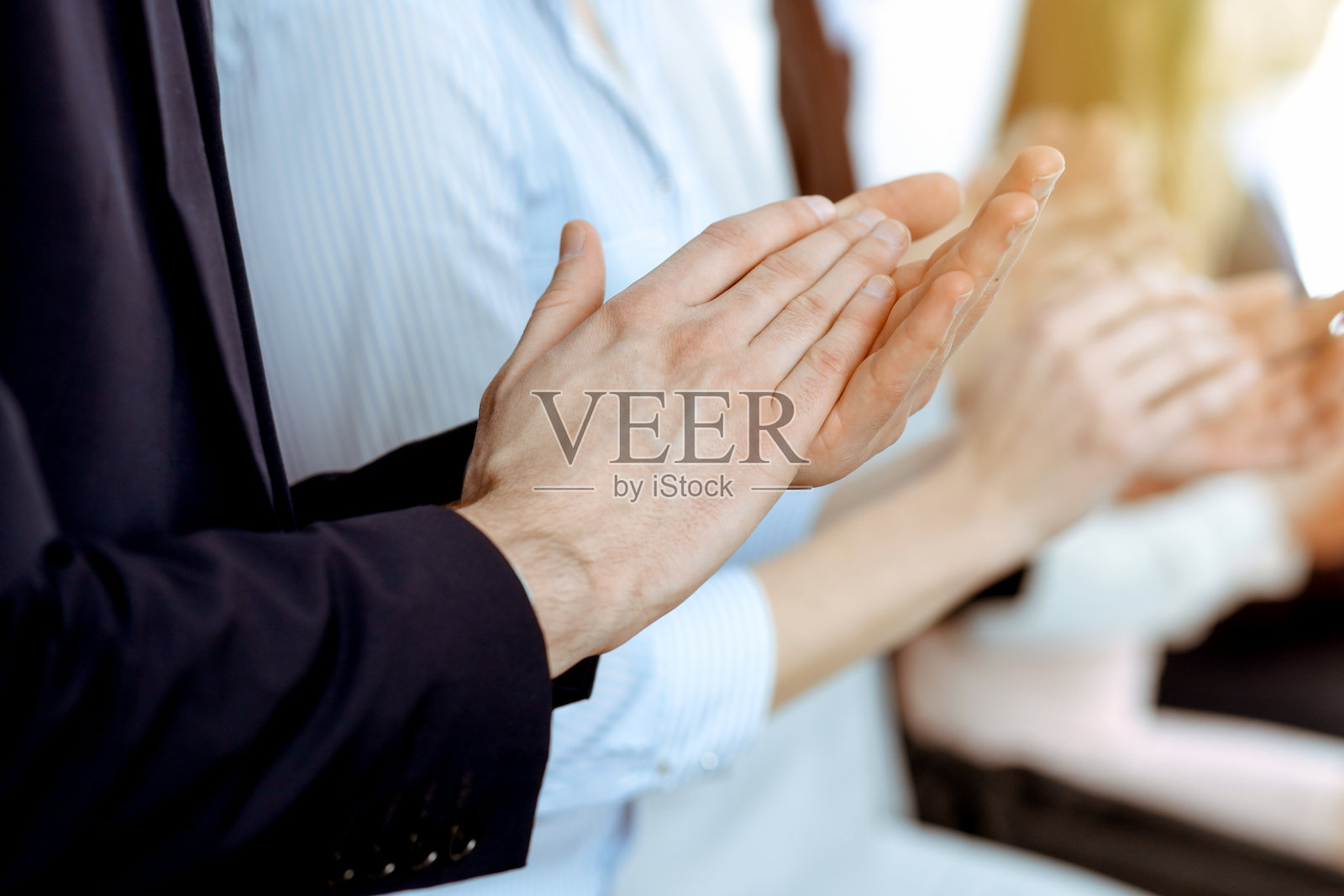 商务人士在会议或会议上拍手、鼓掌、举手。一群不知名的商人和妇女在现代白人办公室。成功的团队合作或企业培训理念。照片摄影图片