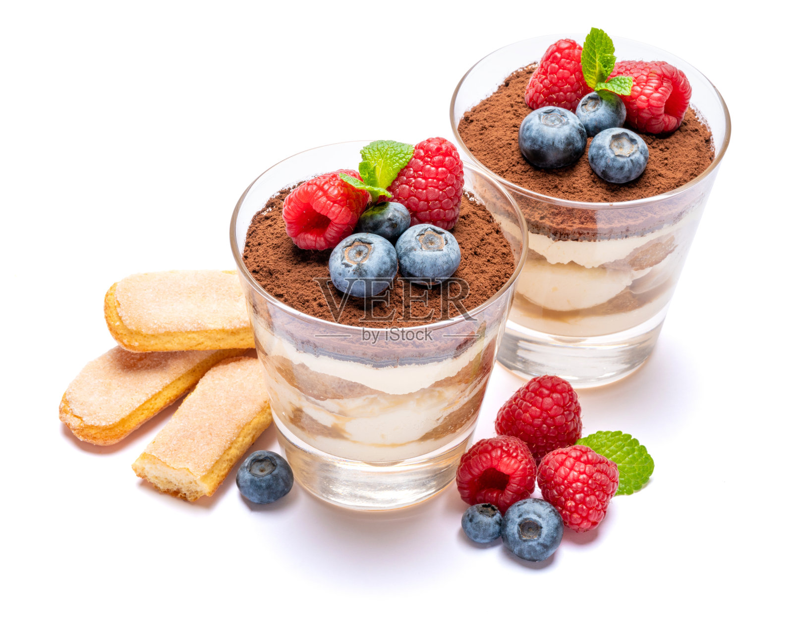 经典的提拉米苏甜点与蓝莓和覆盆子在玻璃杯和savoiardi饼干孤立在一个白色的背景与修剪路径照片摄影图片