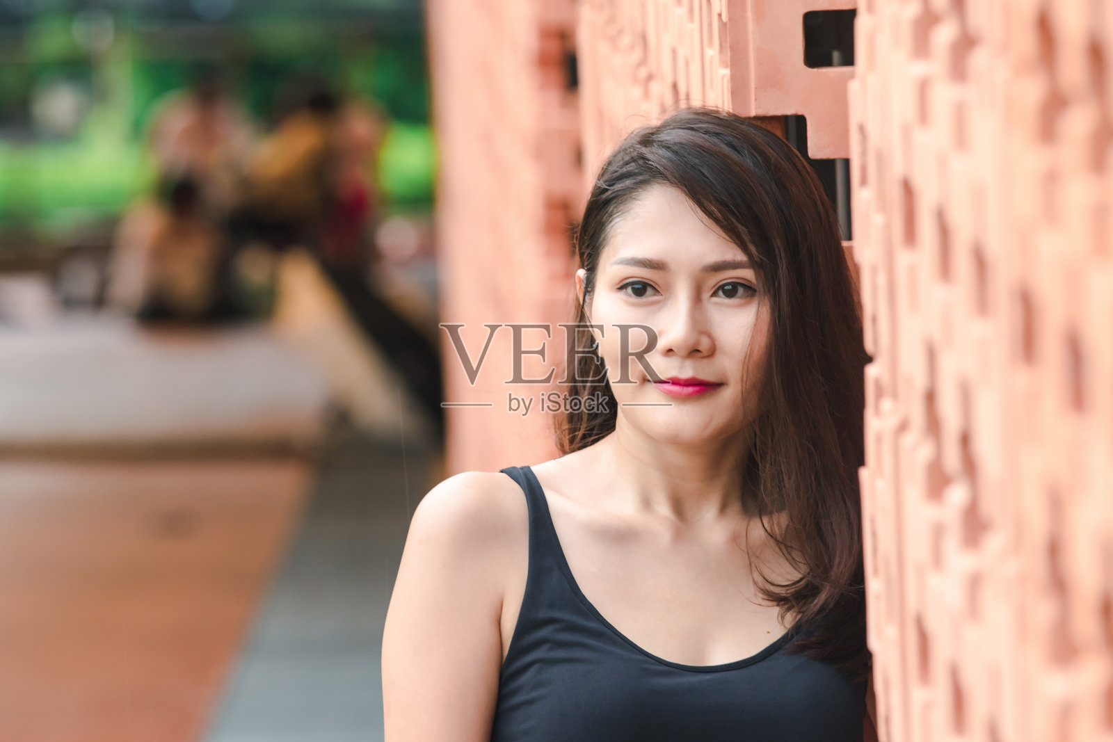 站在砖墙上的女人照片摄影图片