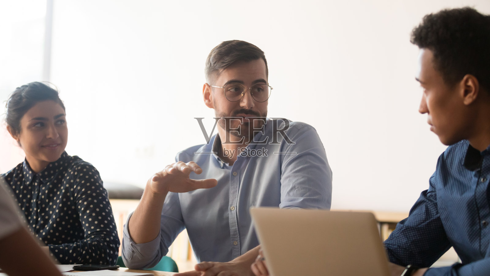 在办公室开会的时候,不同的同事在讨论各自的想法照片摄影图片