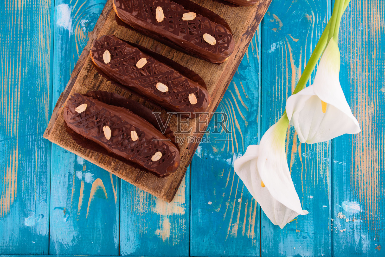 蓝色木桌上放着美味的巧克力和花生泡芙条照片摄影图片