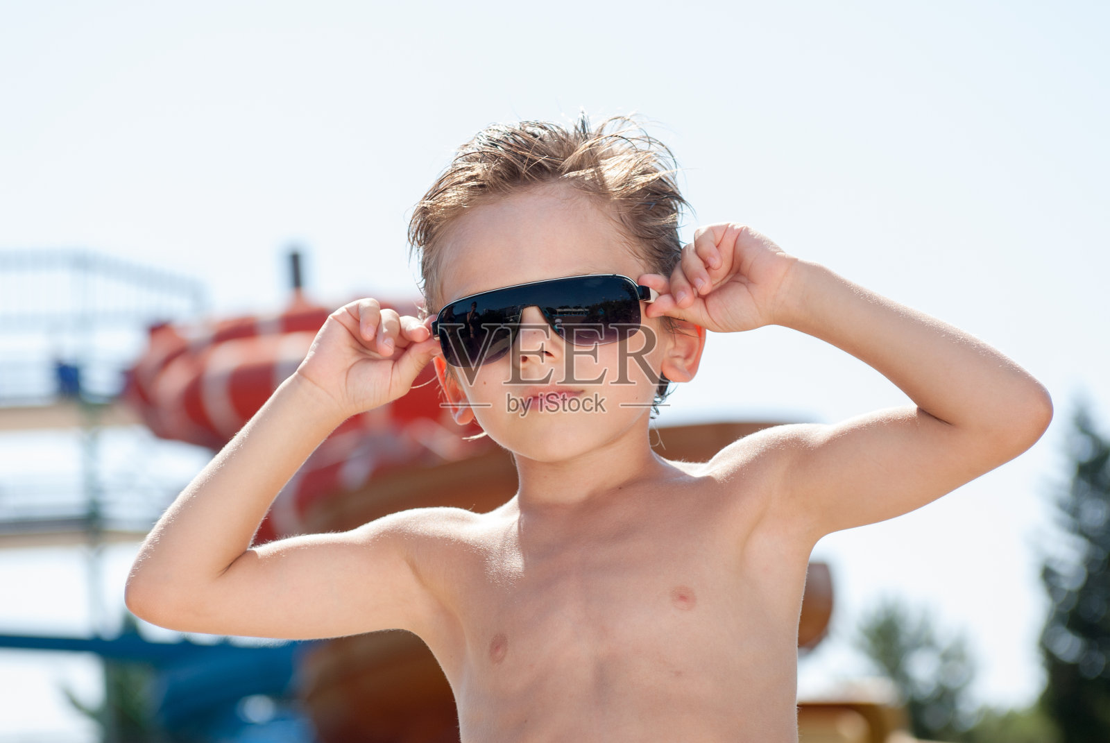 可爱健康时尚的小朋友戴着时髦的太阳镜在夏天的水上乐园度假照片摄影图片