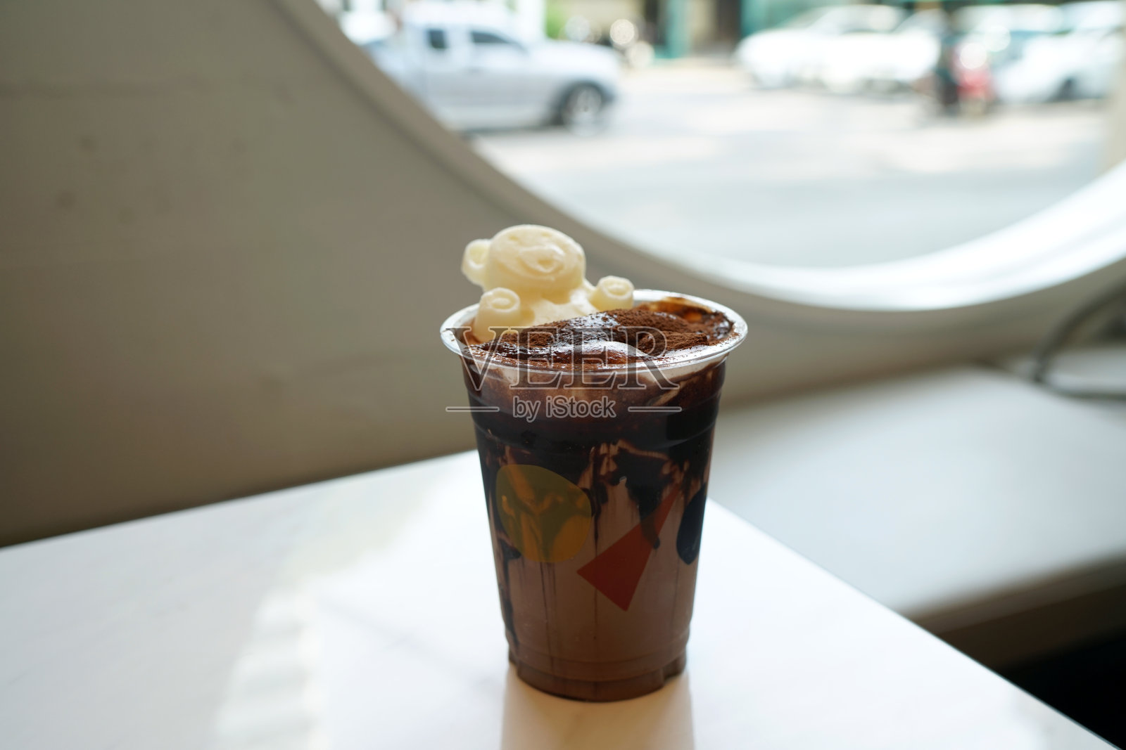 一杯冰黑巧克力加牛奶和巧克力粉在模糊的背景。照片摄影图片