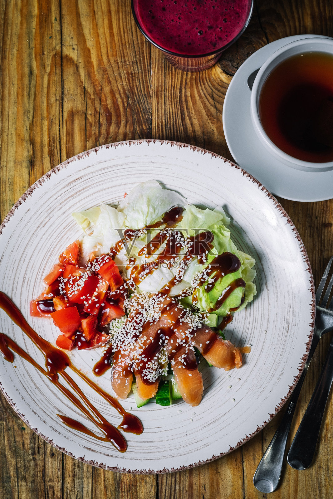 一盘鲑鱼沙拉和一杯以木头为背景的浆果冰沙照片摄影图片