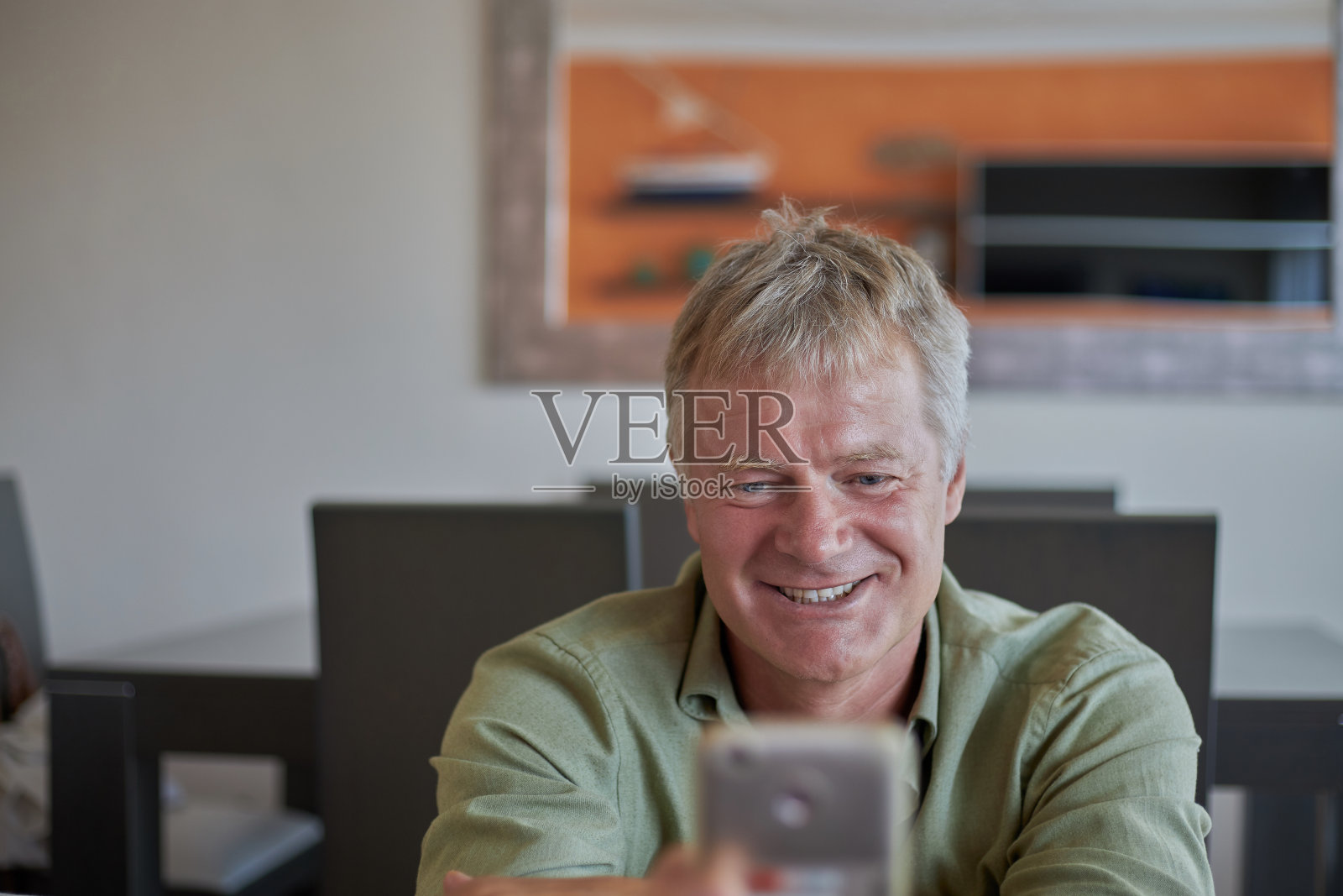 中年帅哥坐在家里的镜头前照片摄影图片