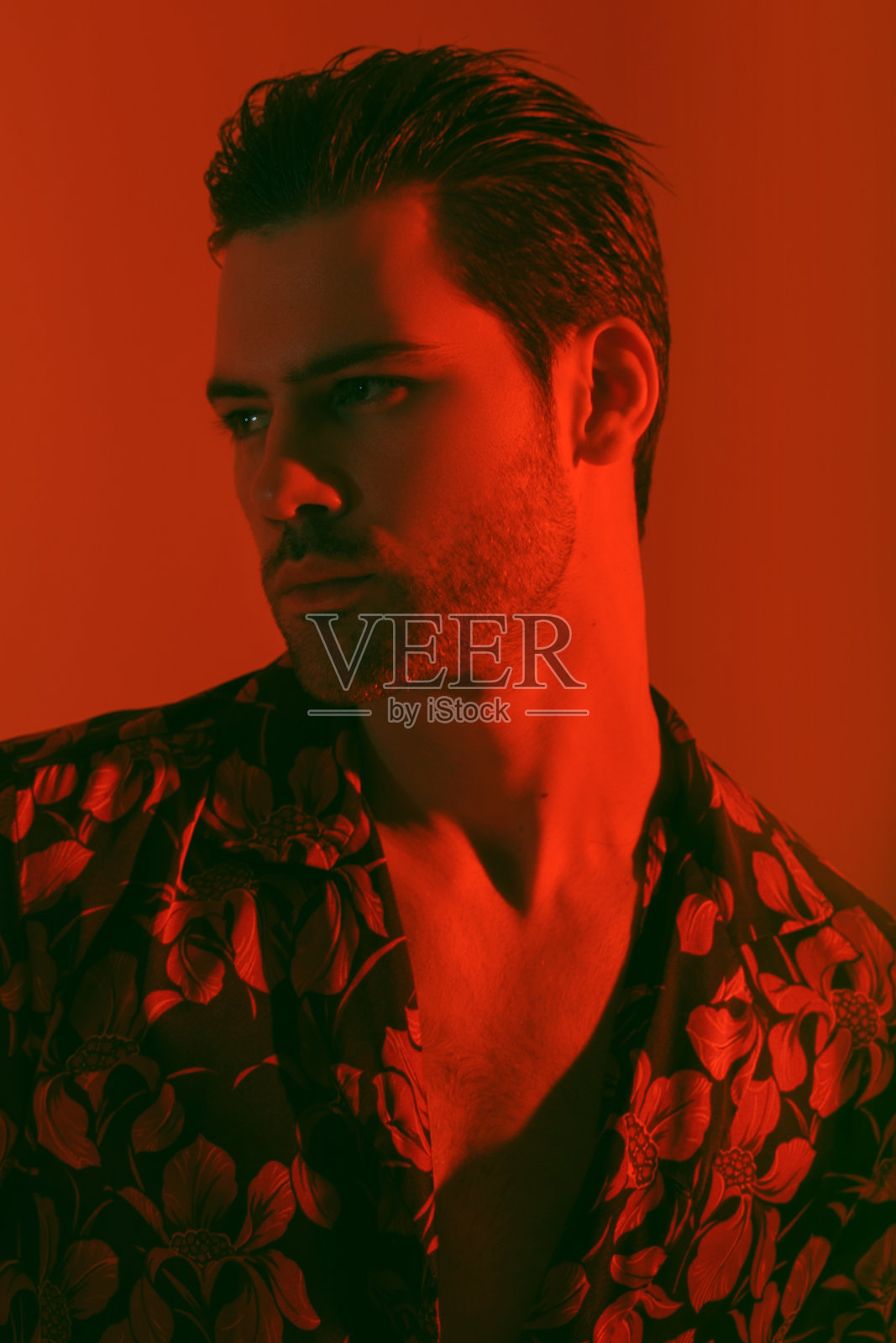 肌肉强壮美丽的男性模特在彩色衬衫与红色和蓝色光红色孤立的字体背景照片摄影图片