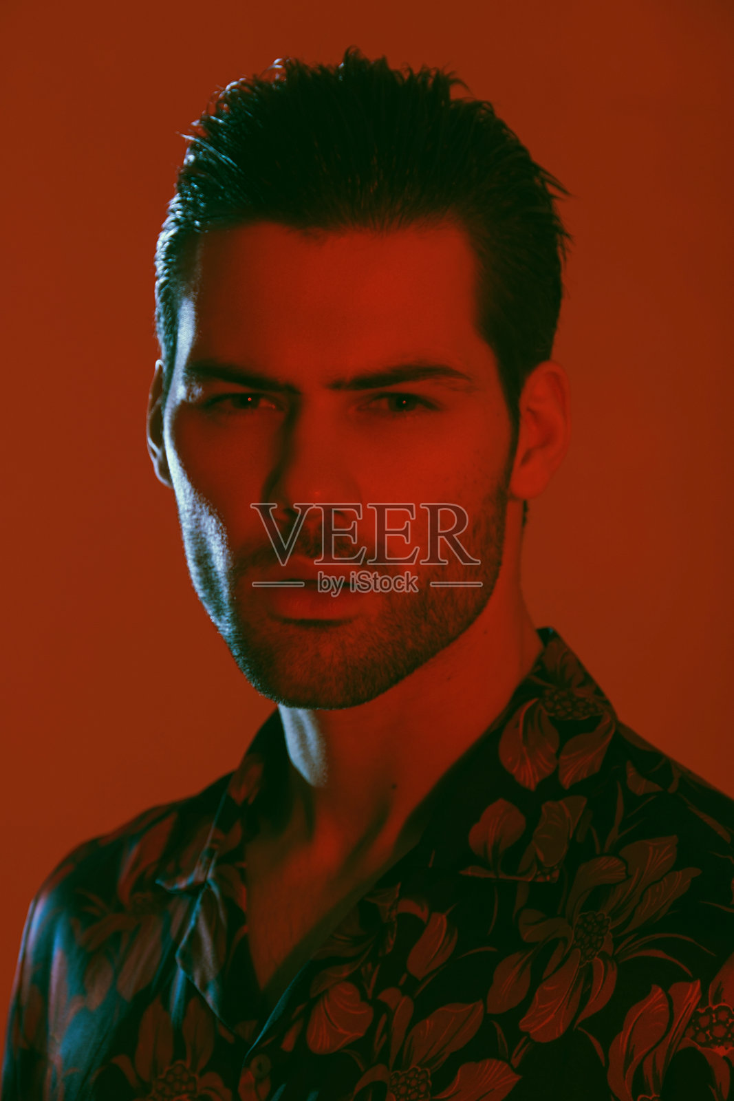 肌肉强壮美丽的男性模特在彩色衬衫与红色和蓝色光红色孤立的字体背景照片摄影图片