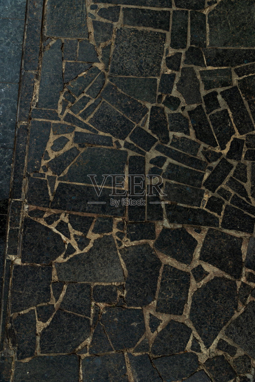 人行道的纹理杂乱,不同颜色的花岗岩石头有许多裂缝照片摄影图片