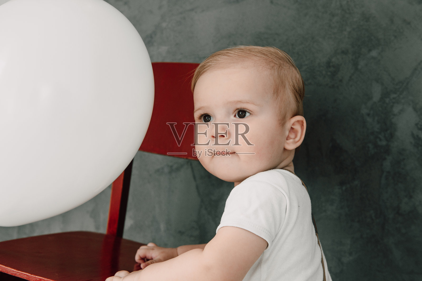 可爱的小男孩开心的微笑庆祝一岁生日的肖像。一个一岁的欧洲小绅士在玩气球照片摄影图片