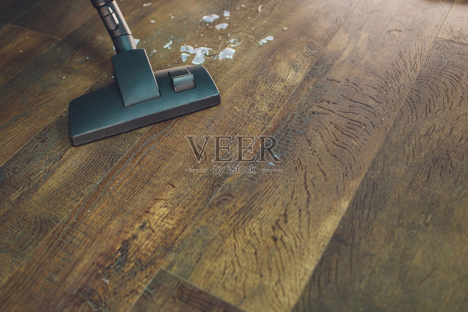 现代吸尘器的黑色吸尘头,正在给地毯吸尘。清洁服务理念。用真空吸尘器处理地毯。照片摄影图片