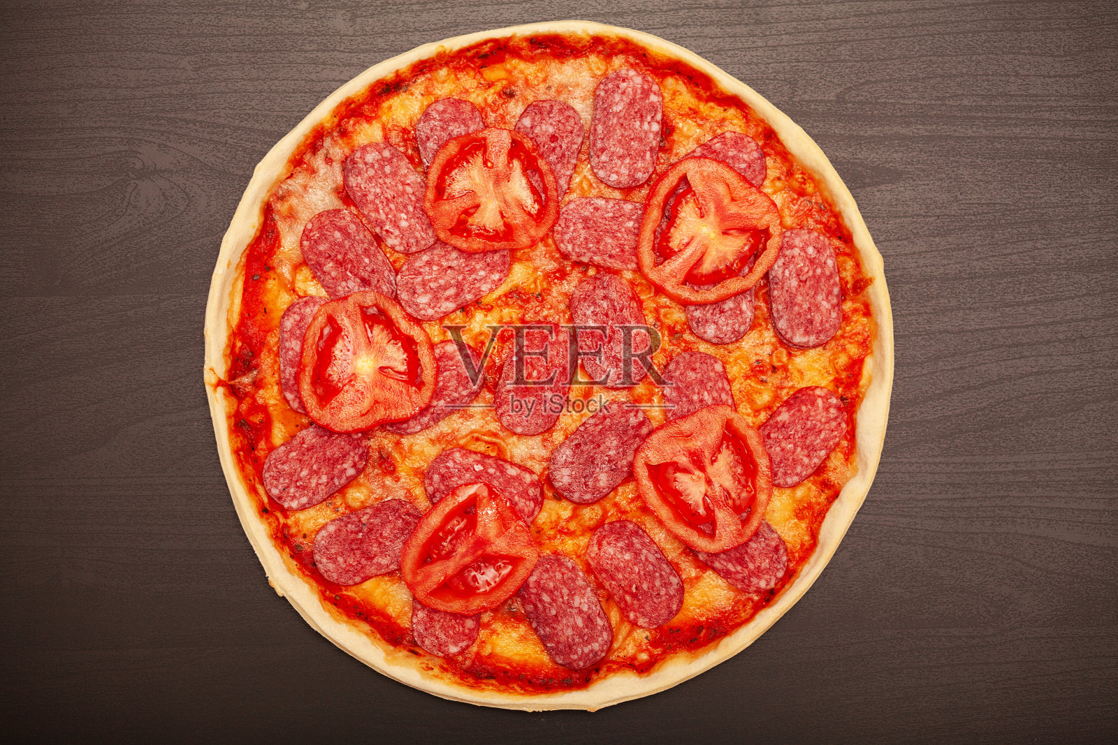 美味的披萨与各种调味材料在一个黑暗的背景照片摄影图片