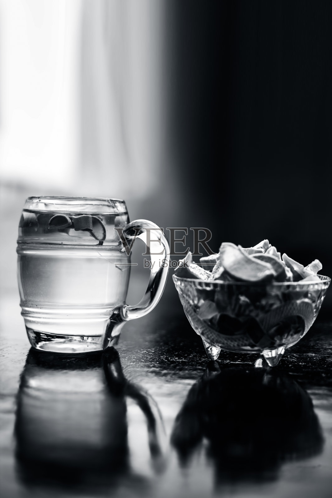 近距离的玻璃杯上的木制表面含有芦荟排毒饮料,连同它的整个原材料与它。垂直拍摄与模糊的背景。照片摄影图片