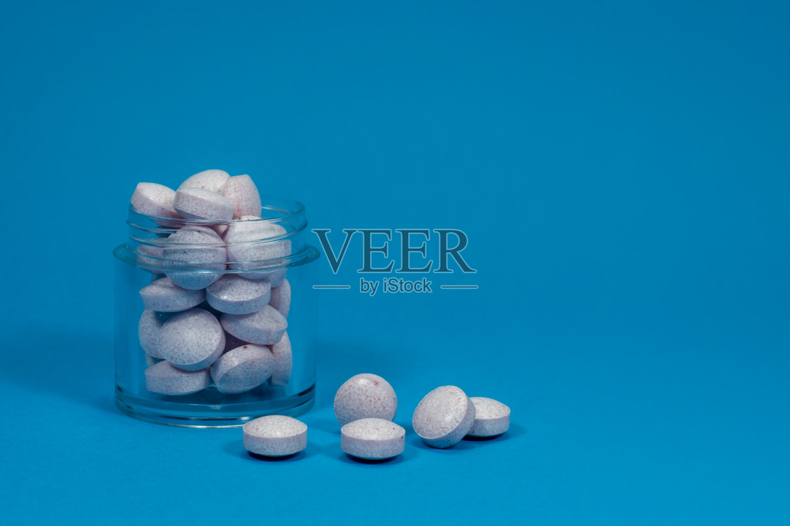 蓝色背景下的药片剂量照片摄影图片