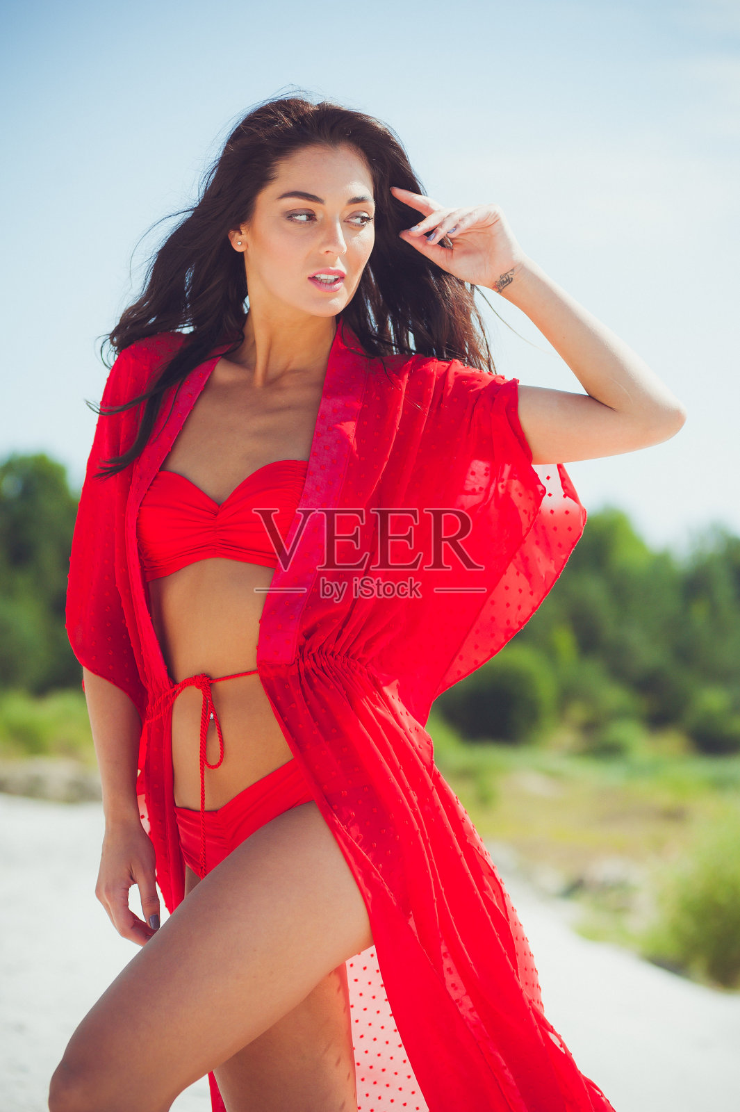 美丽女人的肖像与运动身体穿红色泳衣。白天沙滩上美丽的模特照片摄影图片