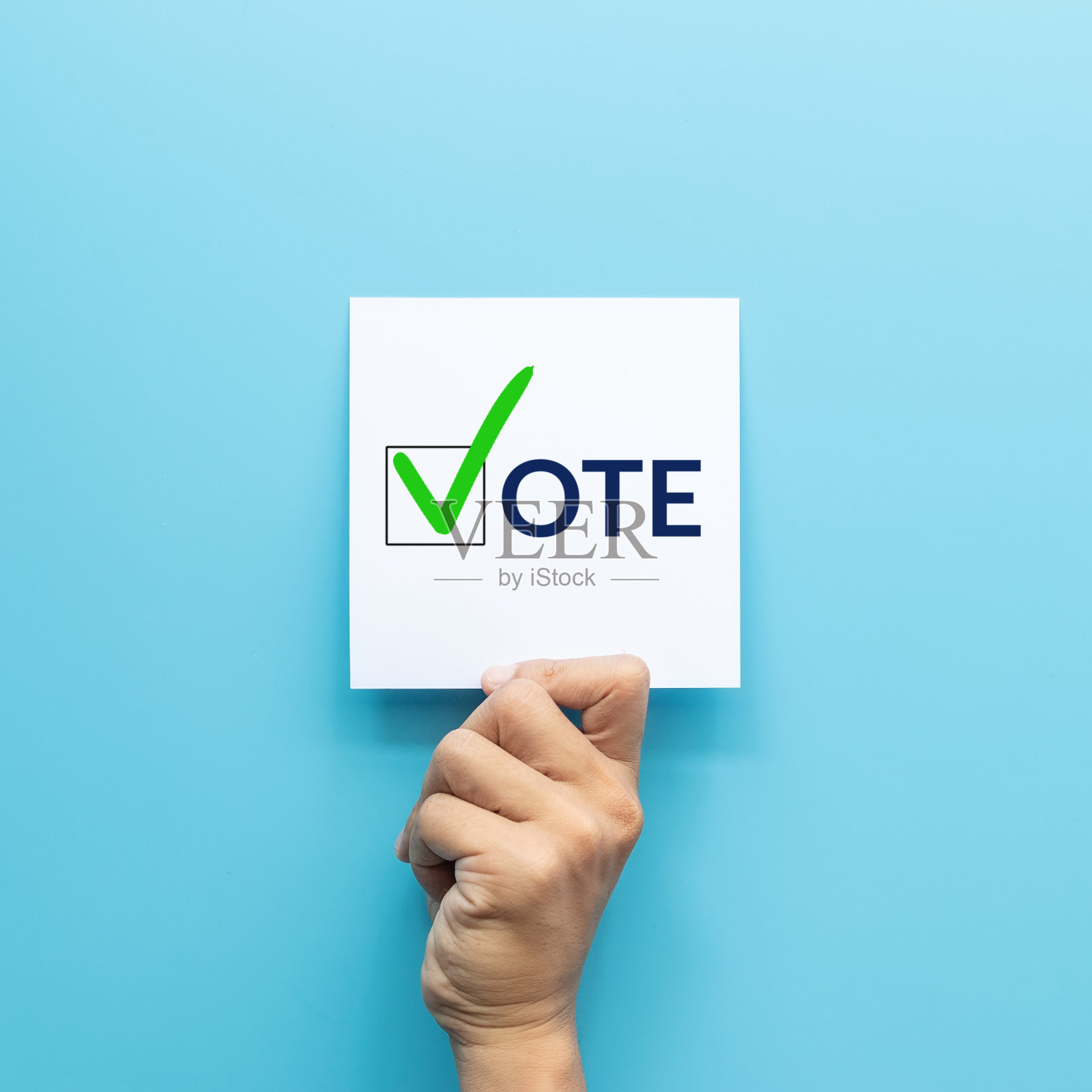 手握白纸与“投票”和绿色复选标记投票符号复选框中的题词孤立在蓝色背景上照片摄影图片