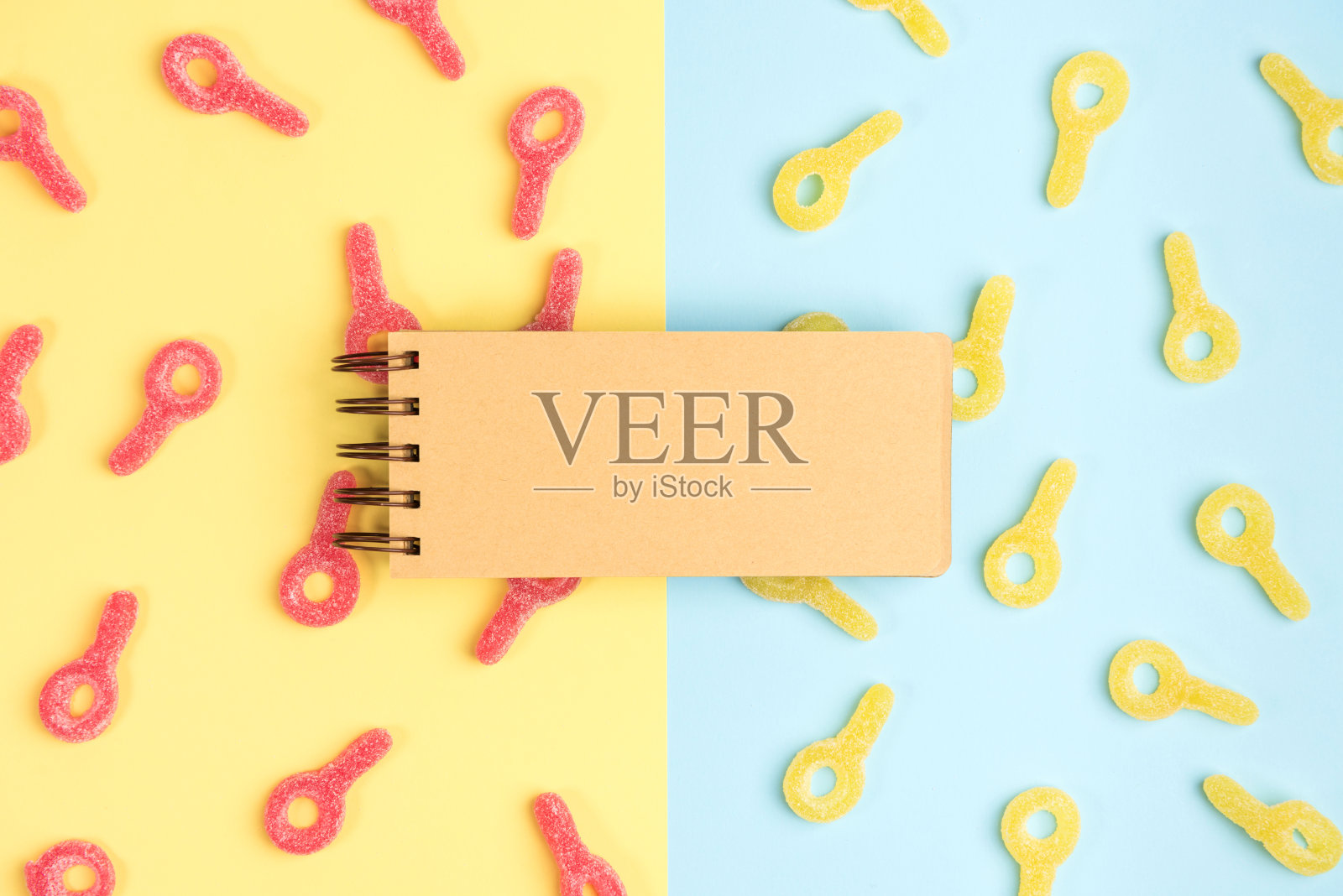 打开空白笔记本的背景橡皮糖。黄色和蓝色背景上的软糖。前视图。照片摄影图片