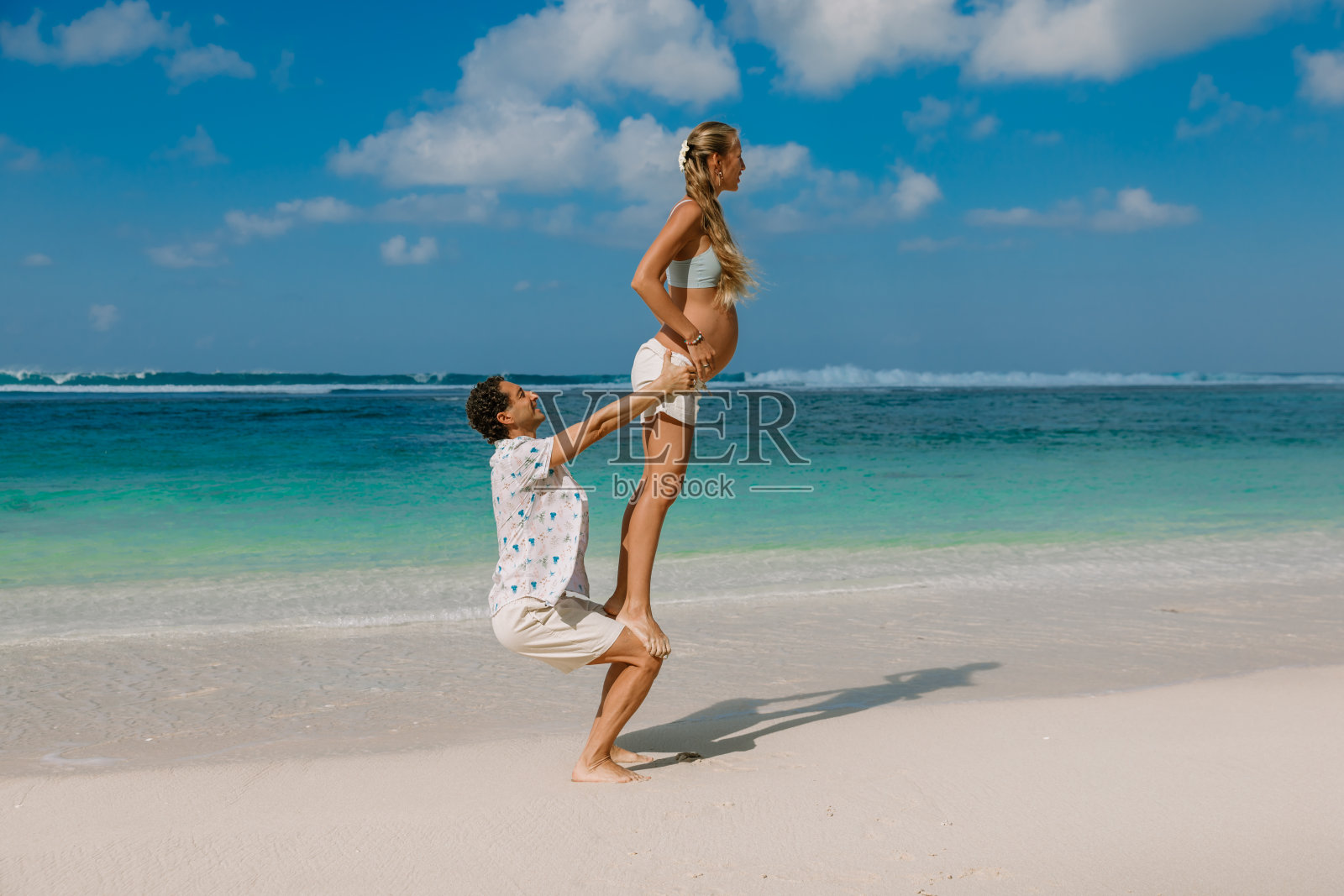 年轻的孕妇和丈夫在热带海滩期待孩子照片摄影图片