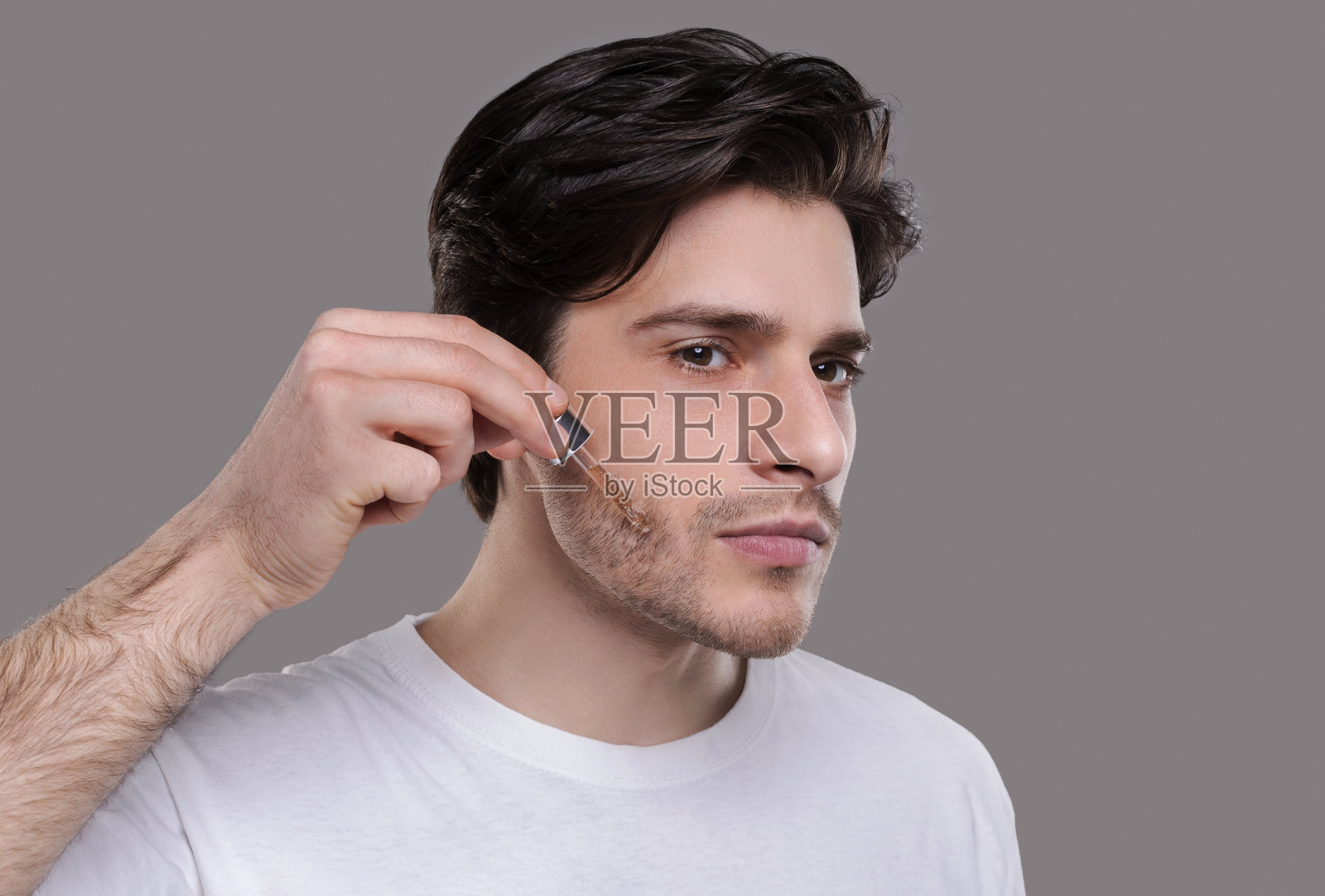 帅哥在脸上涂抹保湿精华液照片摄影图片