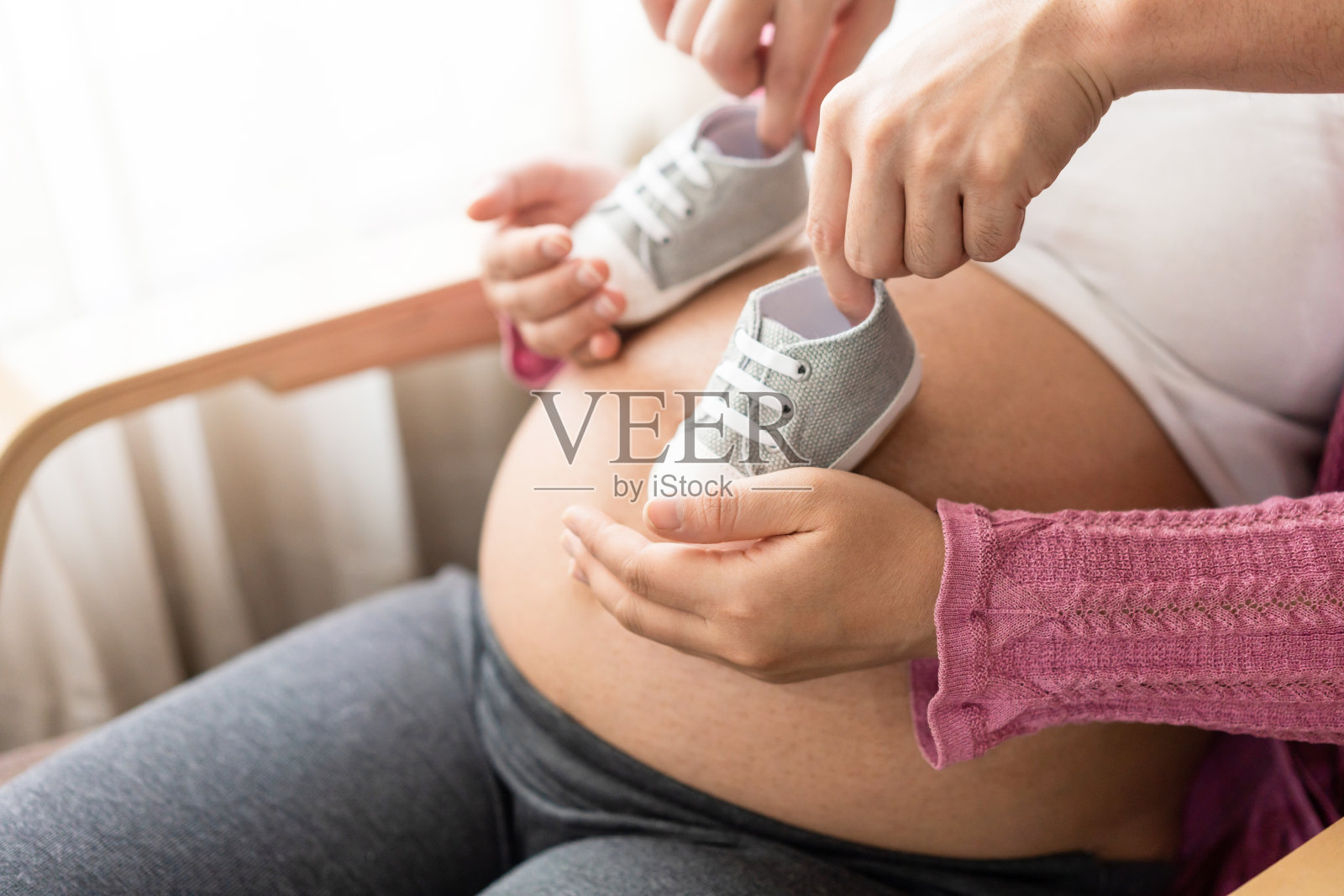 怀孕夫妇在家里感受到爱和放松。照片摄影图片