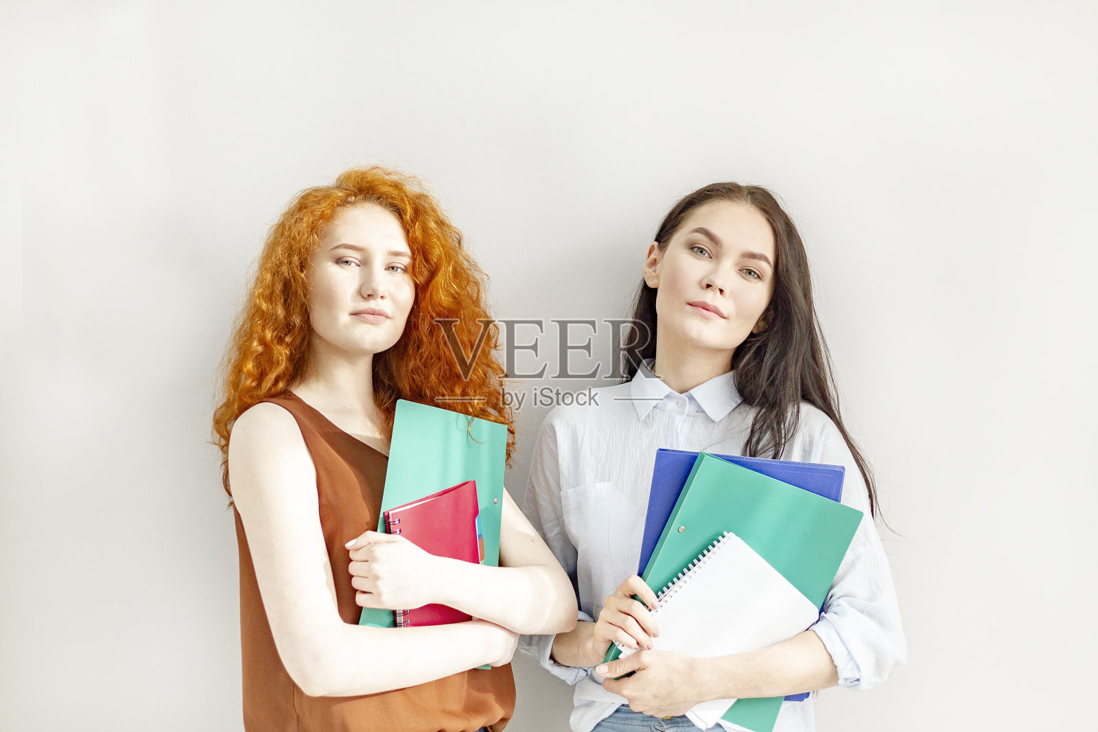 两个年轻成功的女商人,带着迷人的微笑和文件照片摄影图片