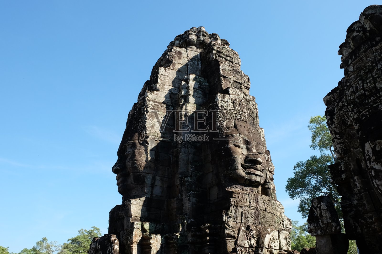 用石块砌成的巨大人脸。柬埔寨巴戎神庙塔上巨大的人脸。古代文明的建筑艺术。照片摄影图片