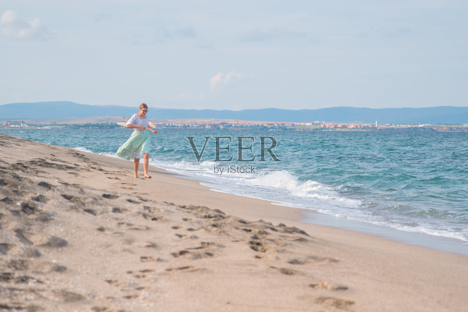 女孩在沙滩上玩耍照片摄影图片