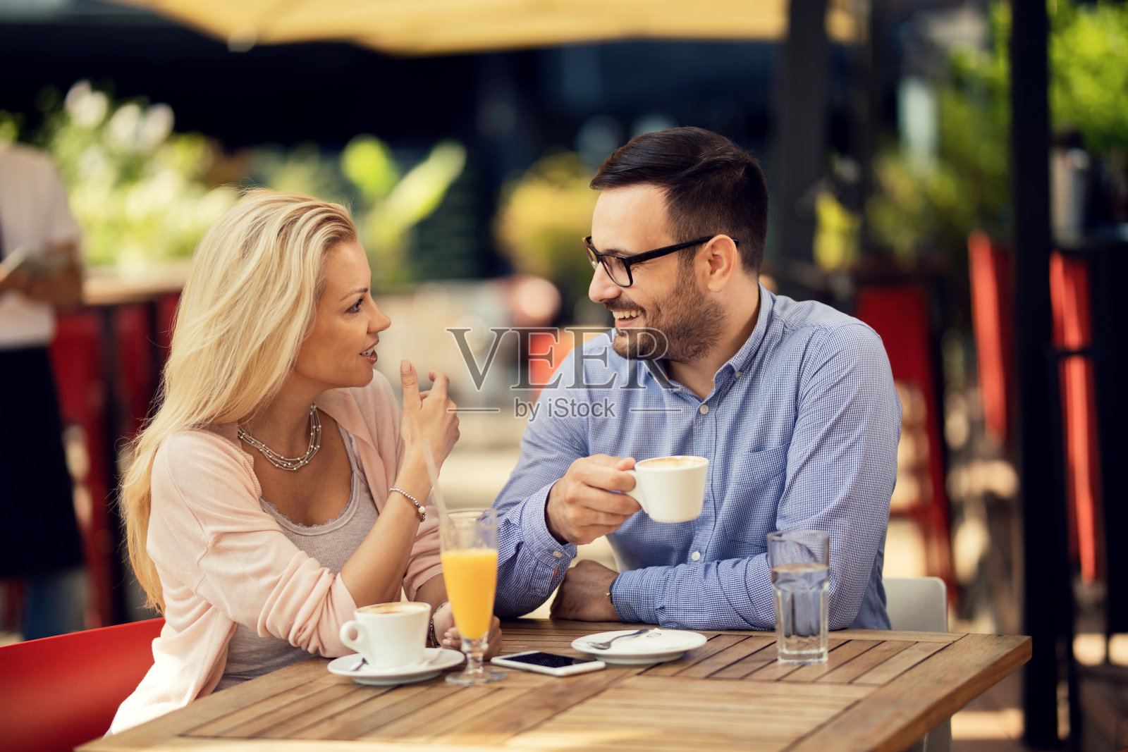 一对幸福的情侣在咖啡馆喝咖啡时聊天。照片摄影图片