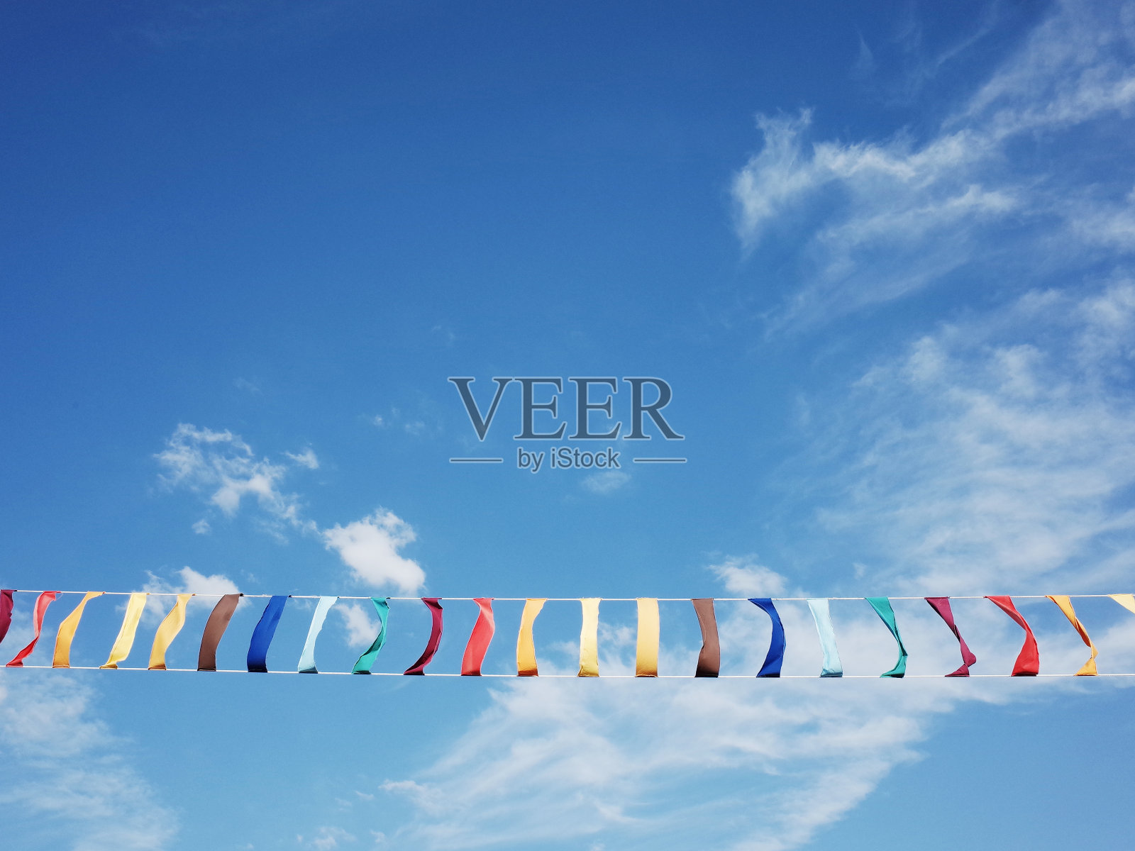 夏日的风吹着挂着蓝天的五彩织物照片摄影图片