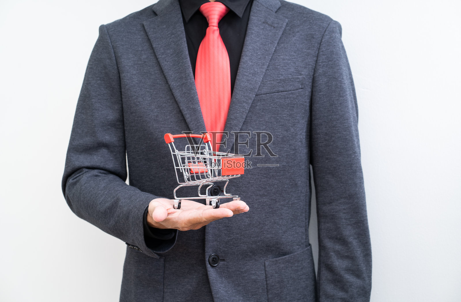 在白色背景下,商人手拿着购物车照片摄影图片
