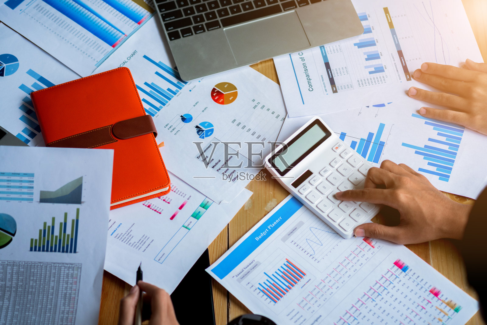 商务人员会议计划预算和成本,战略分析概念,会议使用笔记本电脑,计算器,笔记本。桌子上有很多文件。照片摄影图片