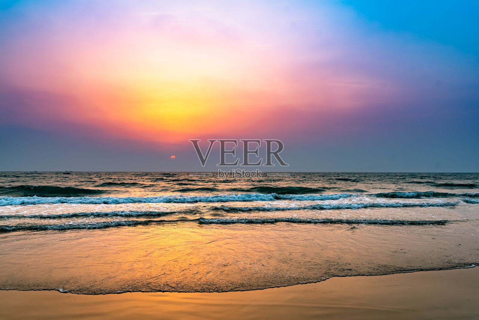 平坦的海滩上五颜六色的日落。照片摄影图片