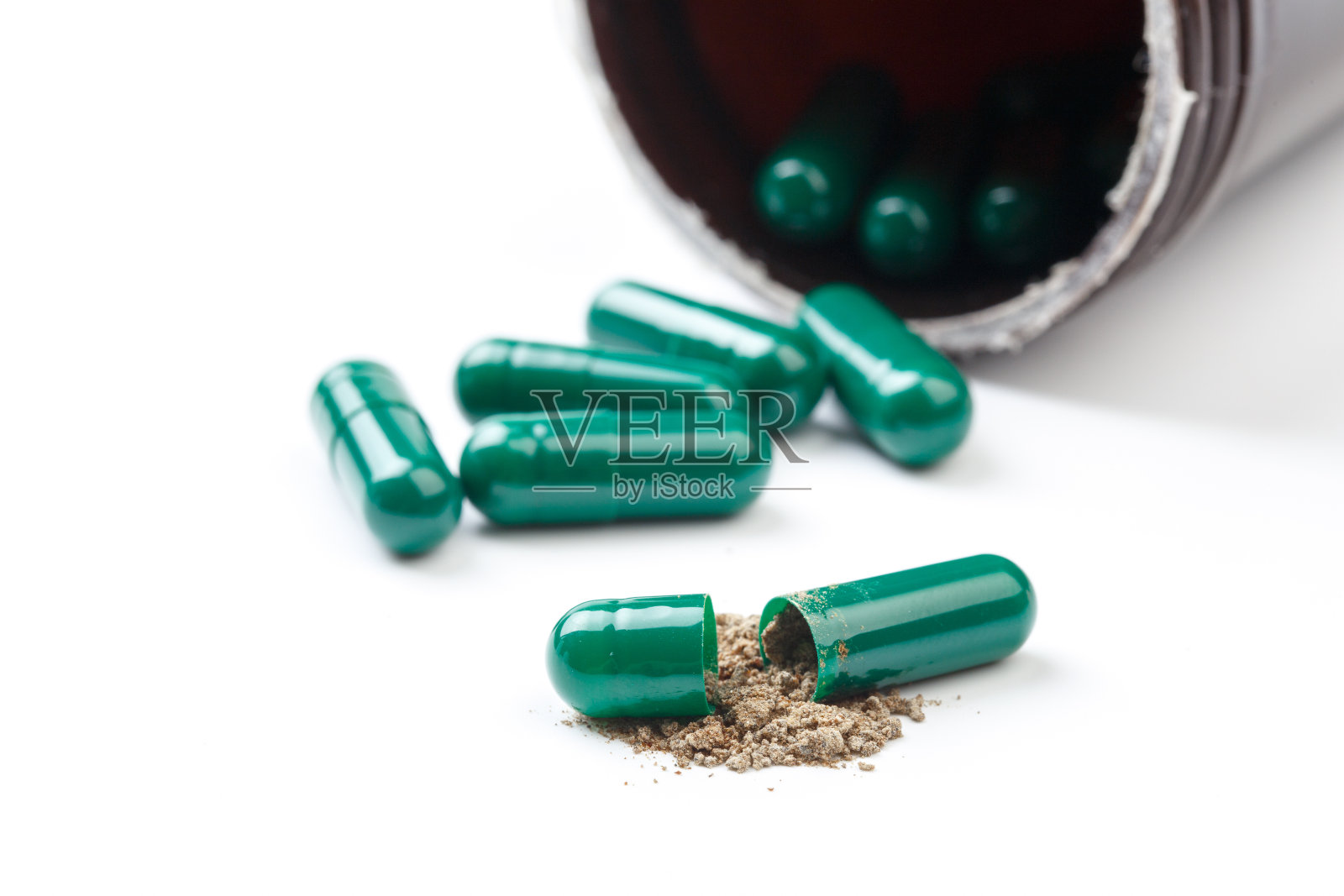 在白色的背景上孤立的绿色草本叶子的草本胶囊照片摄影图片