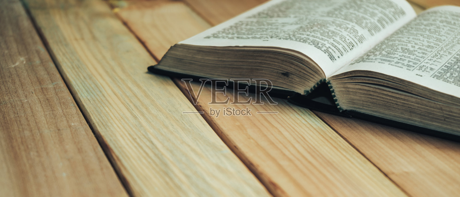 在木头桌子的背景上打开圣经。照片摄影图片