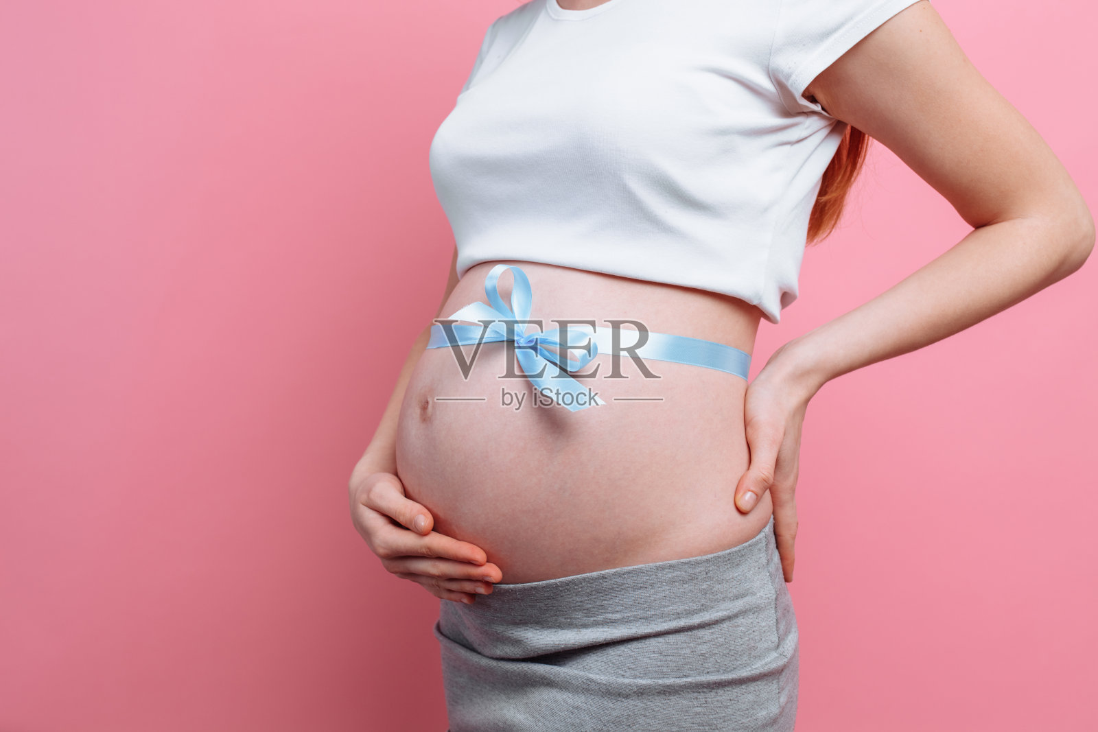 一名孕妇腹部系着一条蓝丝带照片摄影图片