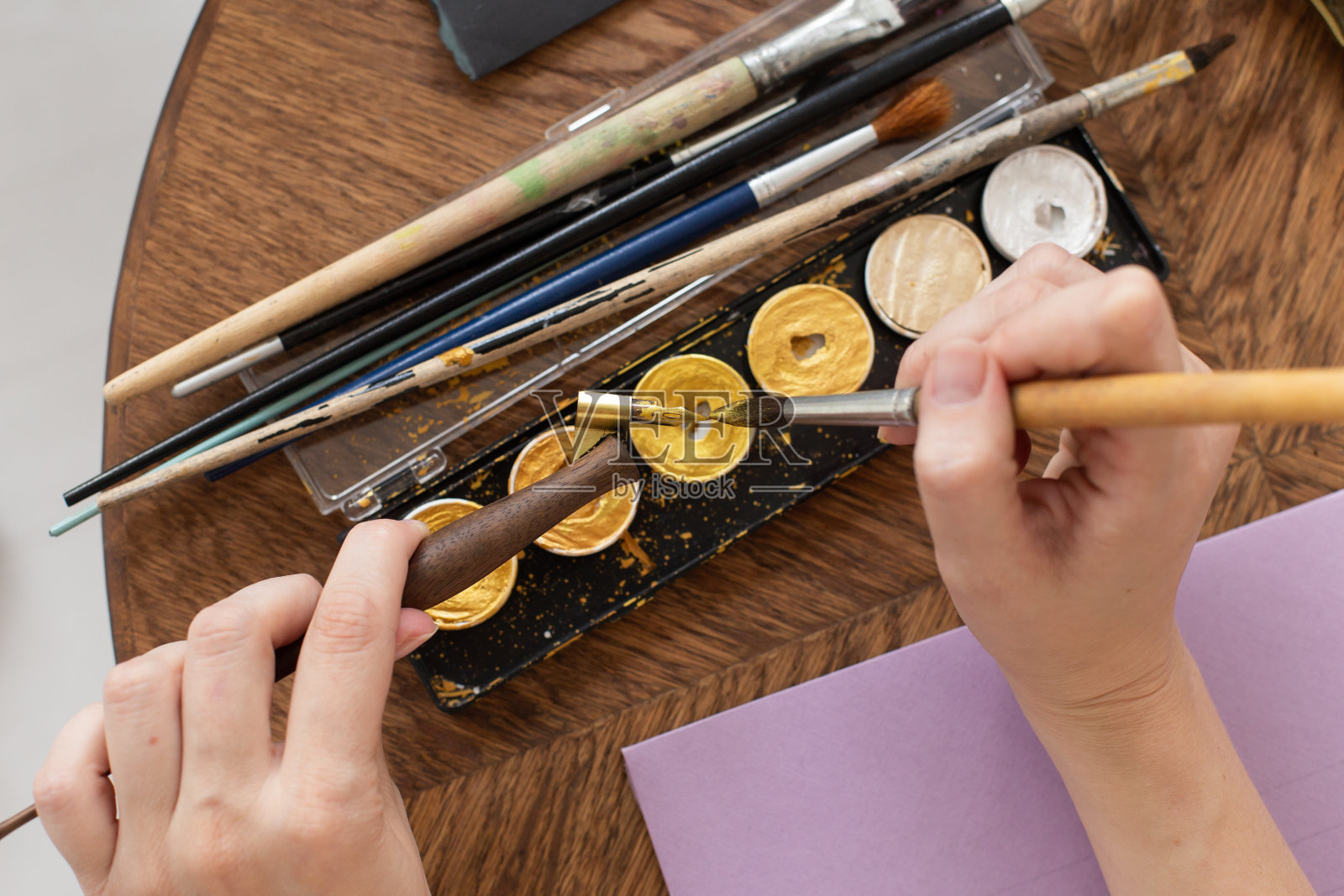 艺术家正准备工作。应用油漆到画笔。特写镜头。创意工作室的氛围。照片摄影图片