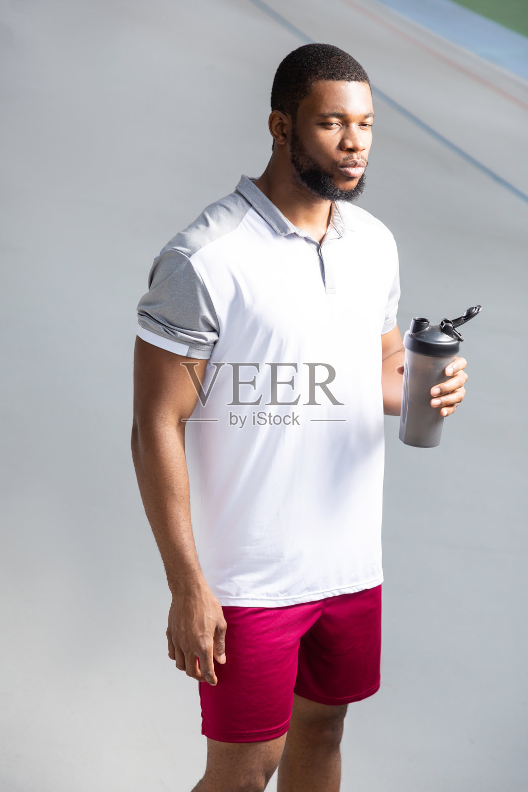 一个年轻人拿着一个塑料运动水瓶照片摄影图片