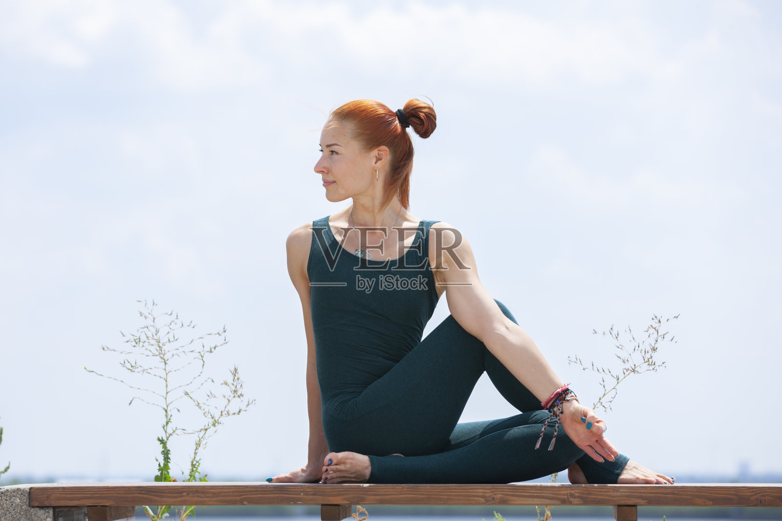 运动强壮的女人在户外练习困难的瑜伽姿势照片摄影图片