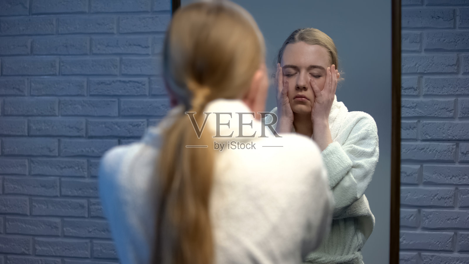 穿着浴袍的年轻女人绝望地摸着脸,遭受抑郁照片摄影图片