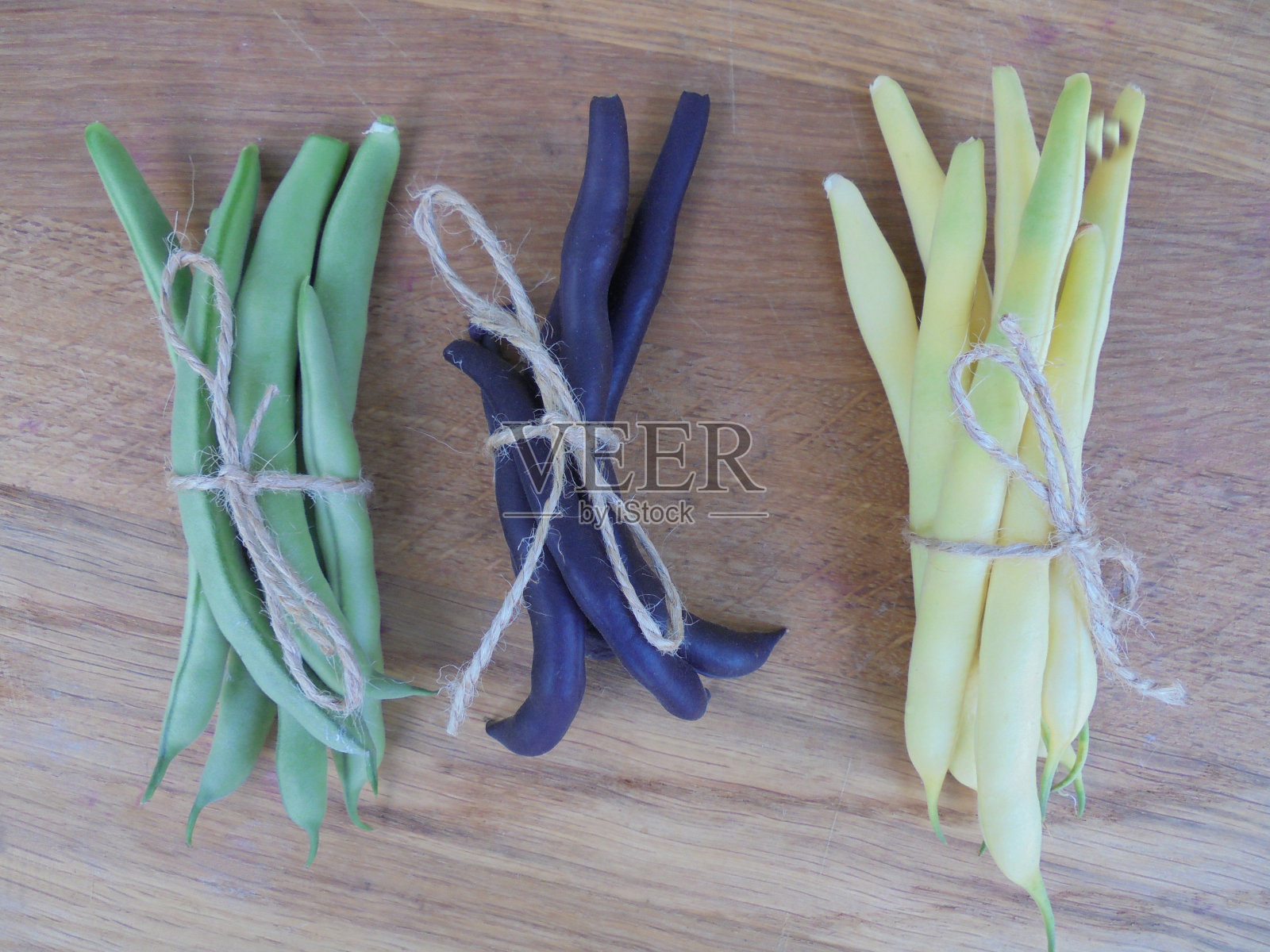 三种青豆捆绑成束躺在一个木制表面俯视图照片摄影图片