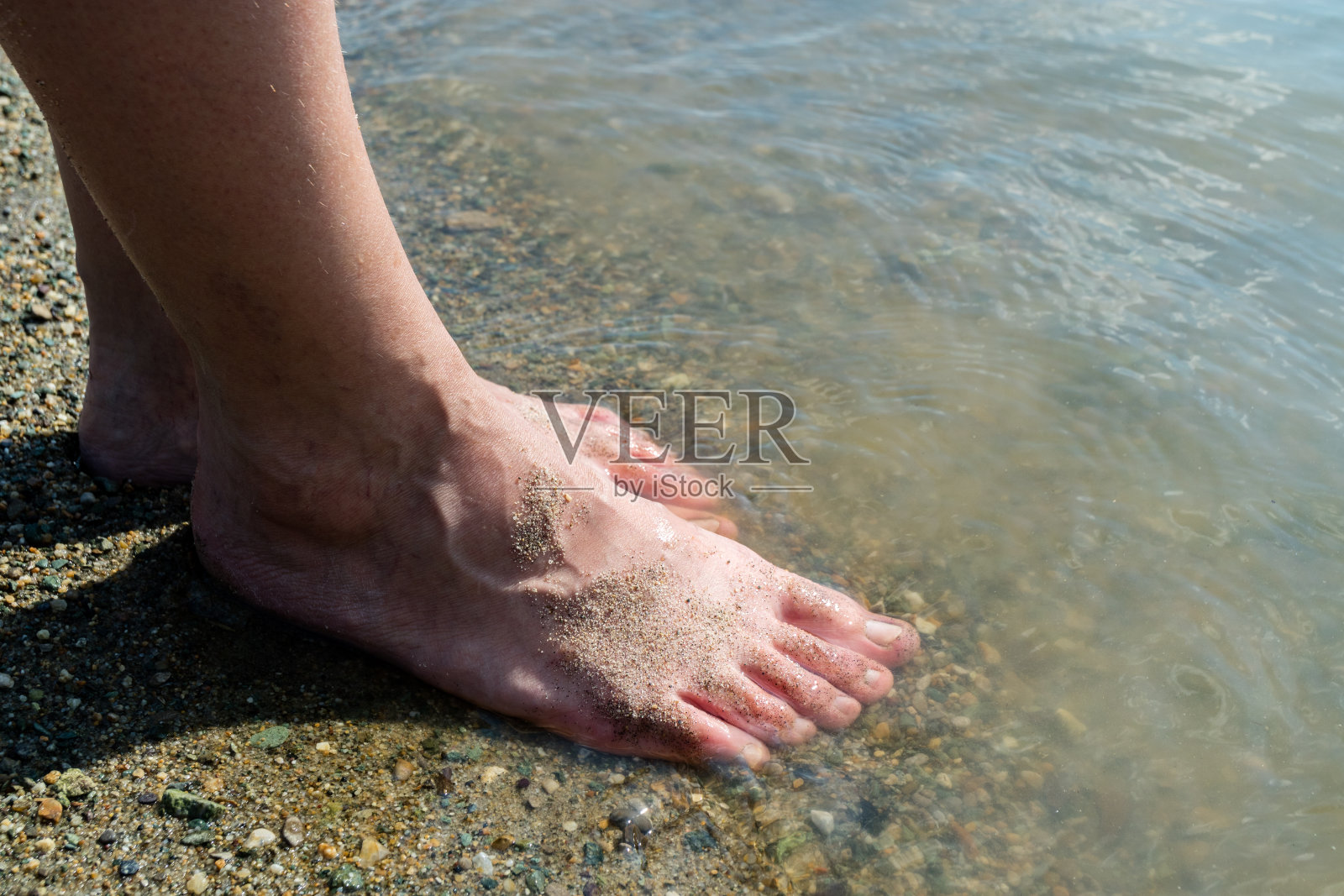 女人的脚在海岸线的海滩上,温暖的夏日照片摄影图片