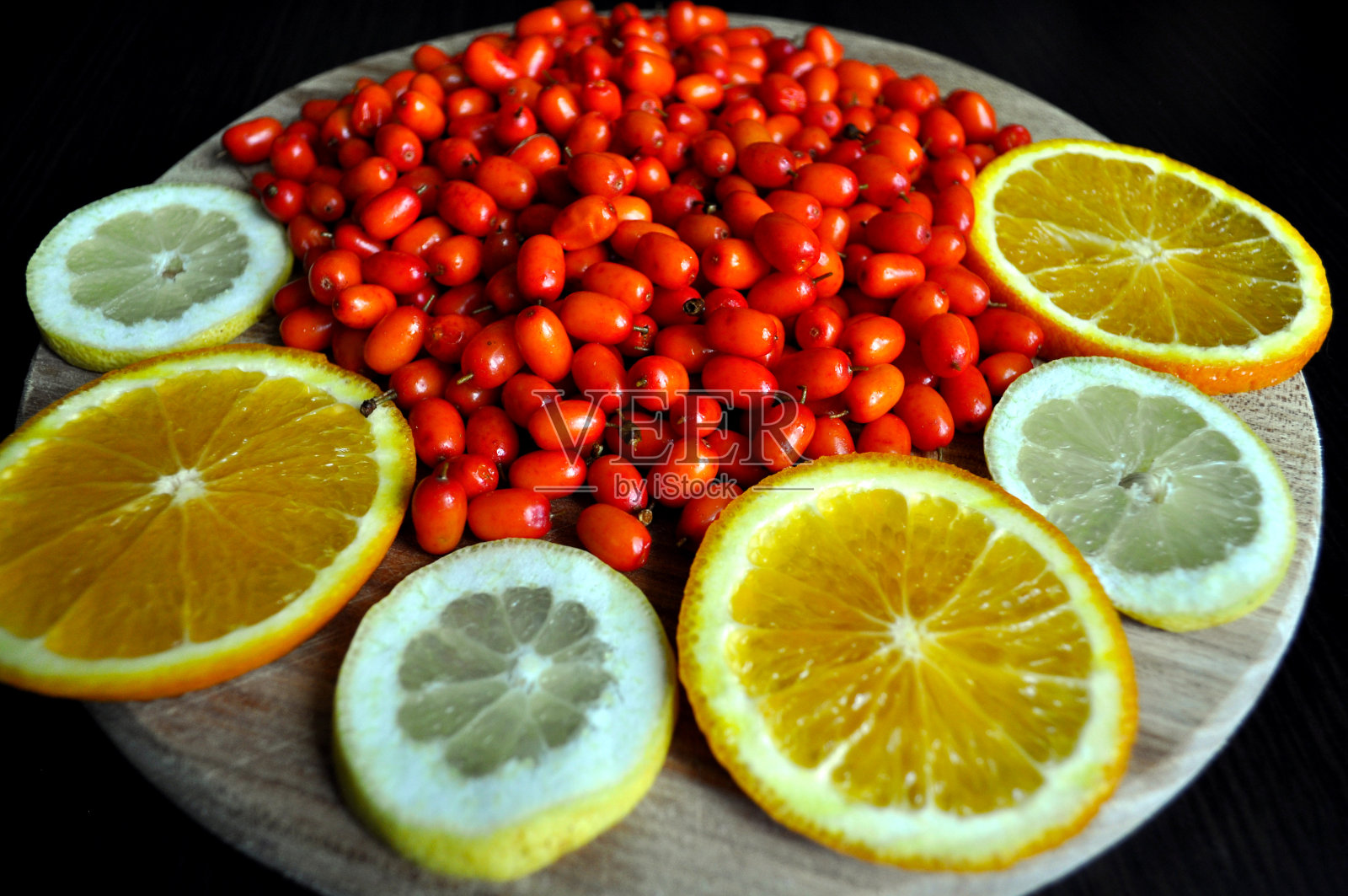 鲜亮的橙色沙棘浆果配上橙子和柠檬照片摄影图片