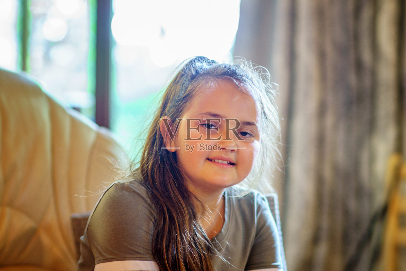 11岁的女孩坐在沙发上照片摄影图片