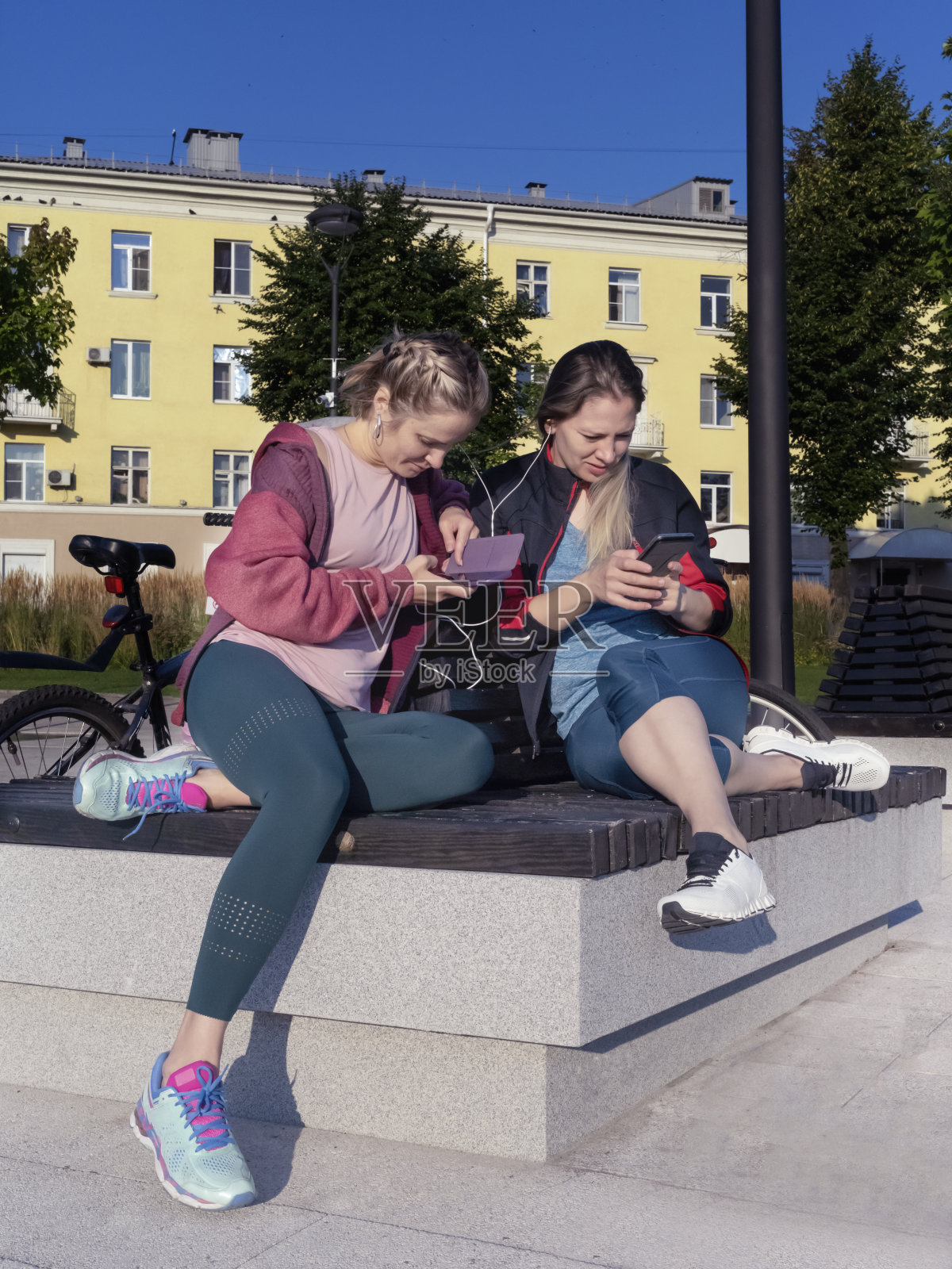 女孩们骑完自行车后休息。照片摄影图片