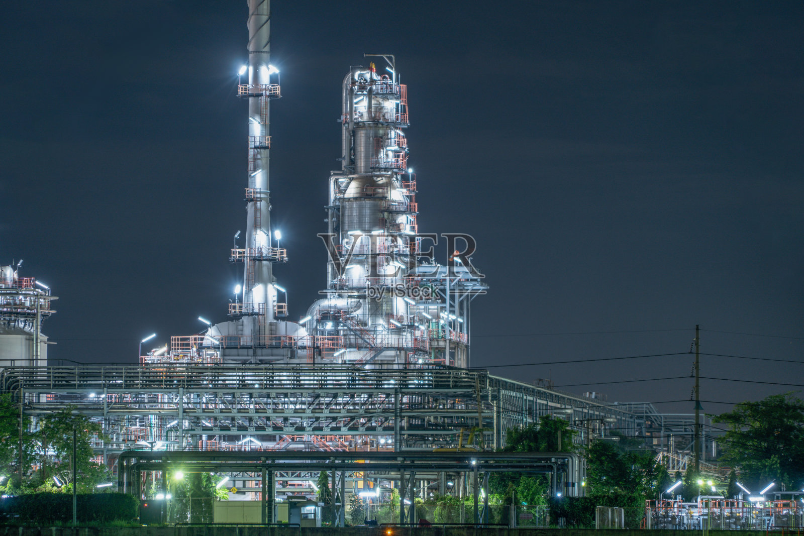 泰国曼谷邦纳区石化、炼油厂和海上工业工程概念。工业中的石油、天然气储罐管道。夜间的现代金属工厂。照片摄影图片