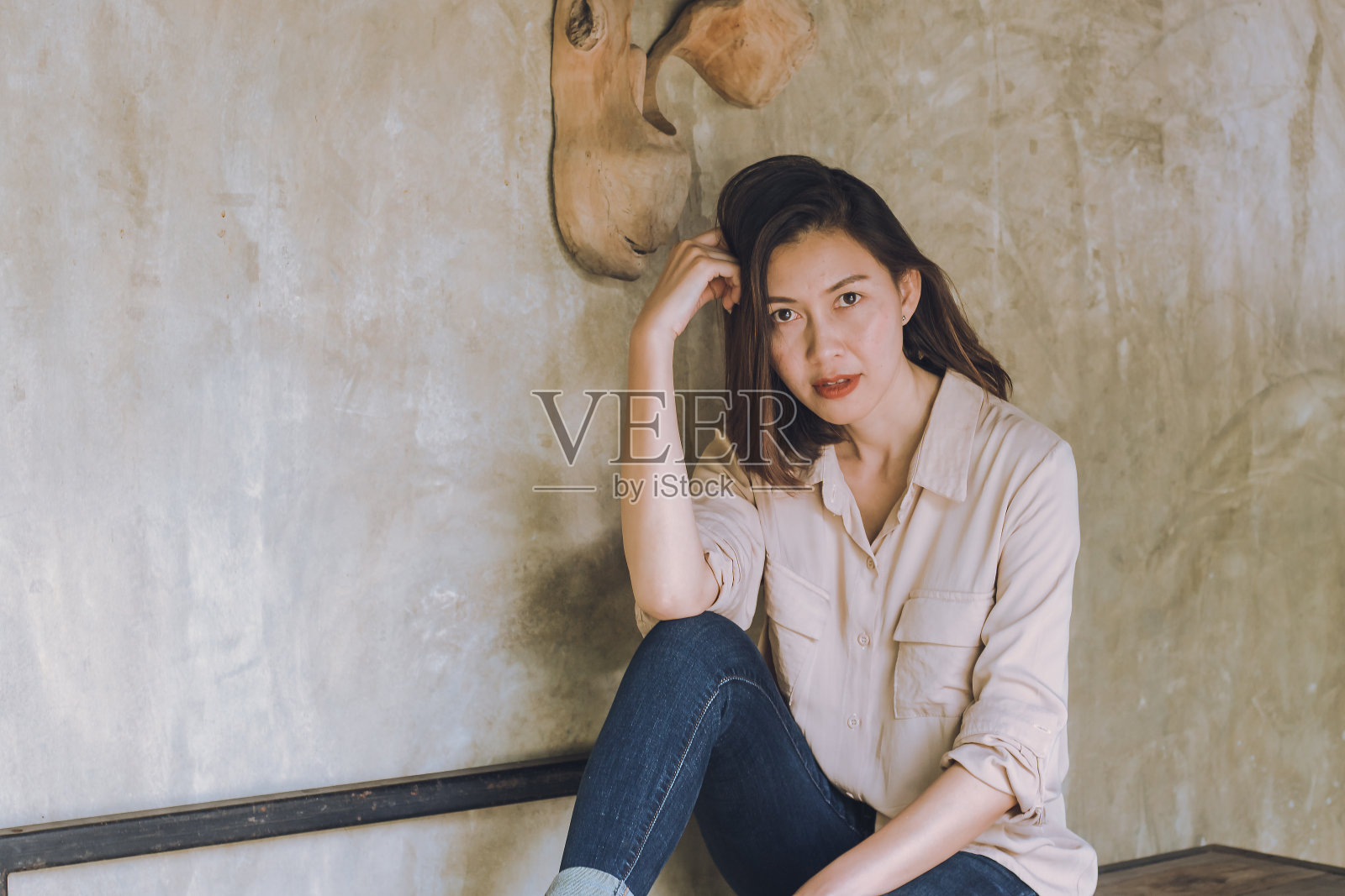 妇女们靠着旧墙坐着。照片摄影图片